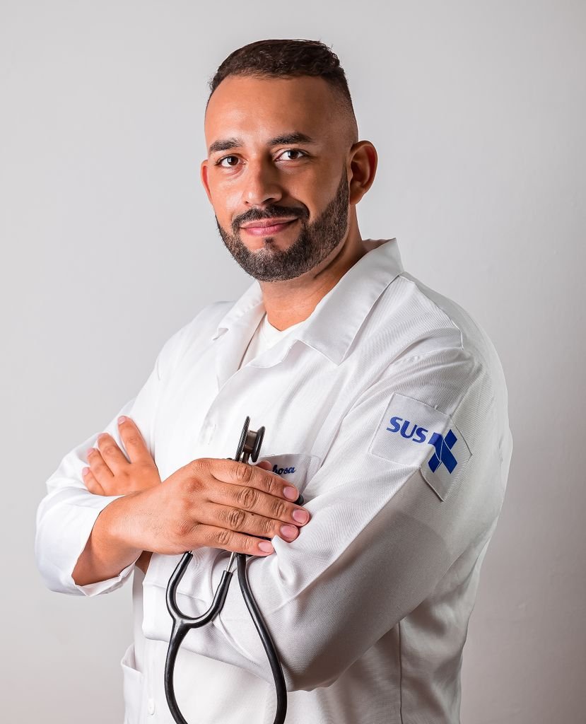 Portrait of a confident male doctor in a white coat with a stethoscope, posing in a studio setting.